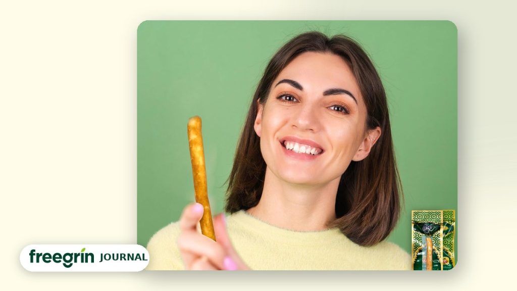 Smiling woman holding a natural miswak stick — Freegrin guide to getting rid of bad breath naturally